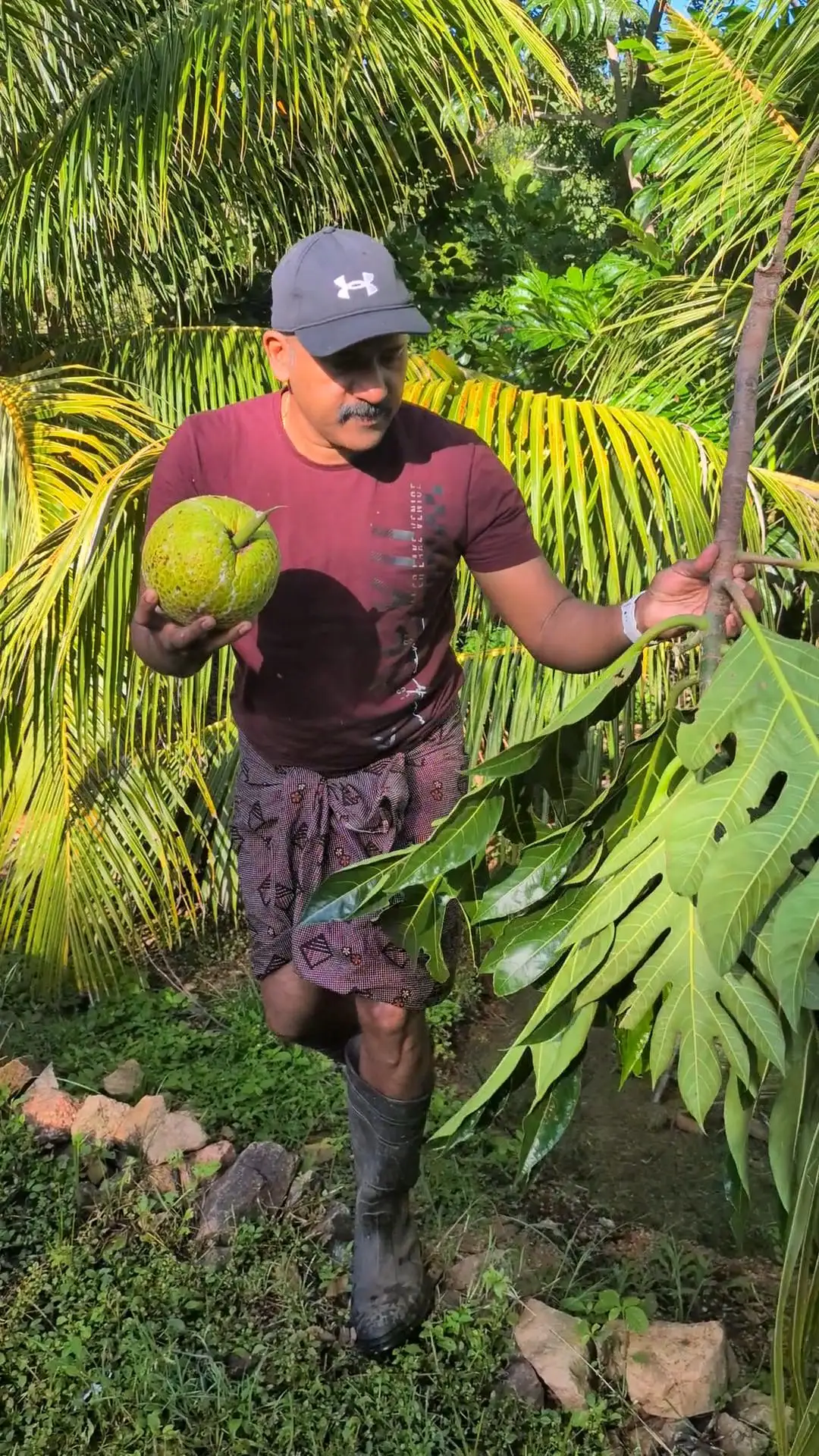 Binu Vadakkedath holding a breadfruit harvested from his Kerala-style backyard garden in Queensland